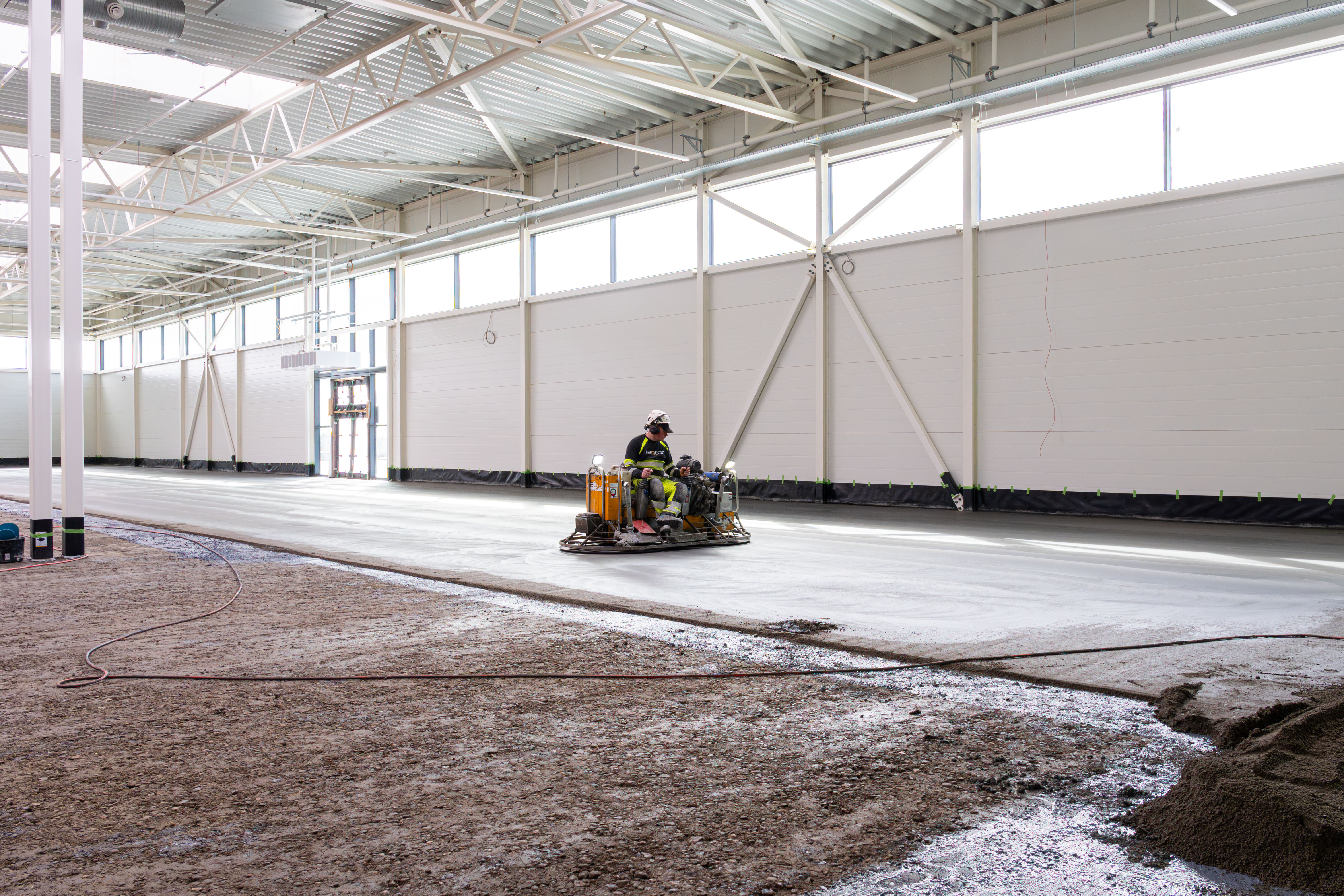 Man polising and grinding new  jointless concrete flooring in Bauhaus